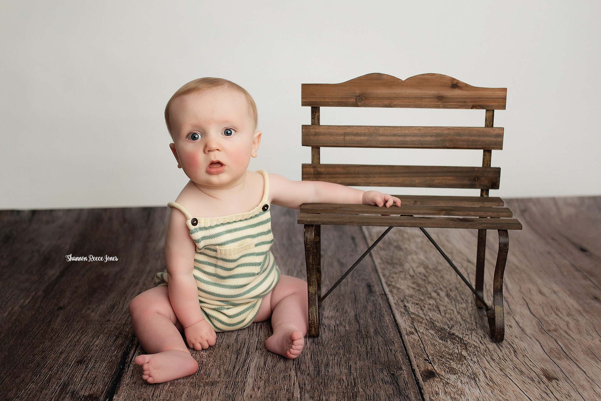 best ages to have your child photographed, baby boy next to bench at 6 month session