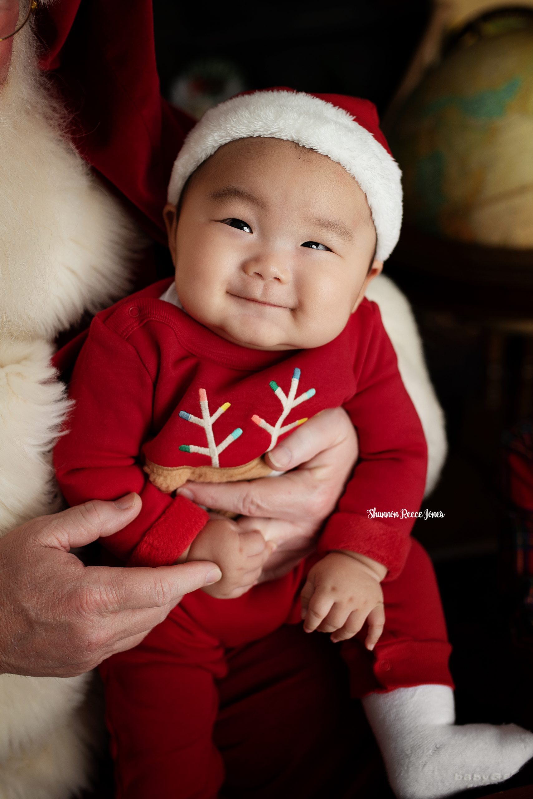 Tips for holiday hosting with a newborn, baby in red Santa outfit
