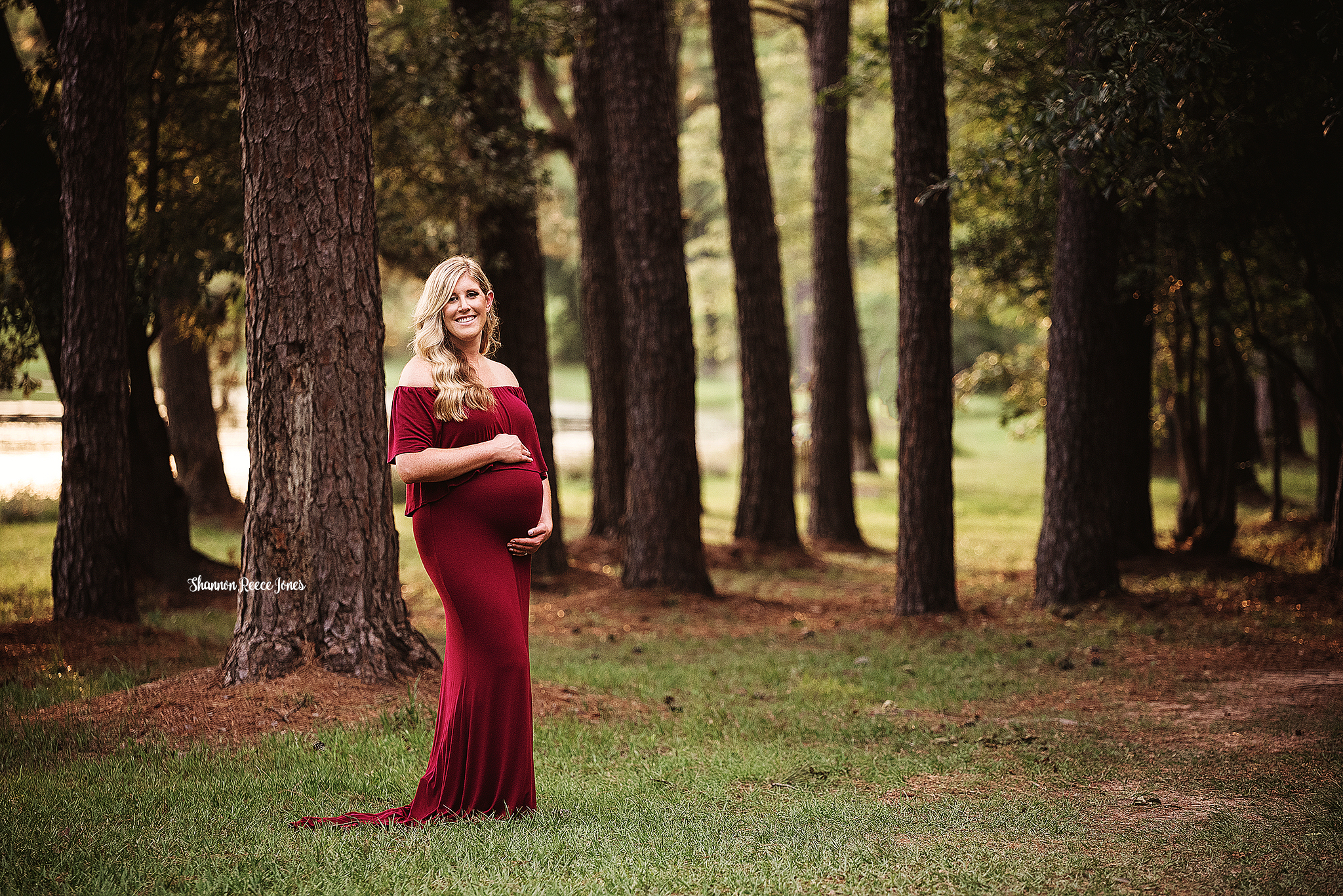 maternity photos, pregnant woman in red gown standing in grass