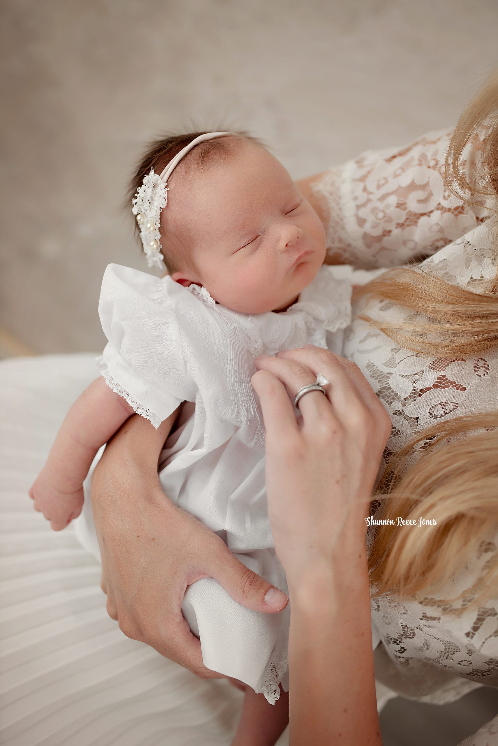 best newborn photographers houston, baby in white dress asleep in mom's arms