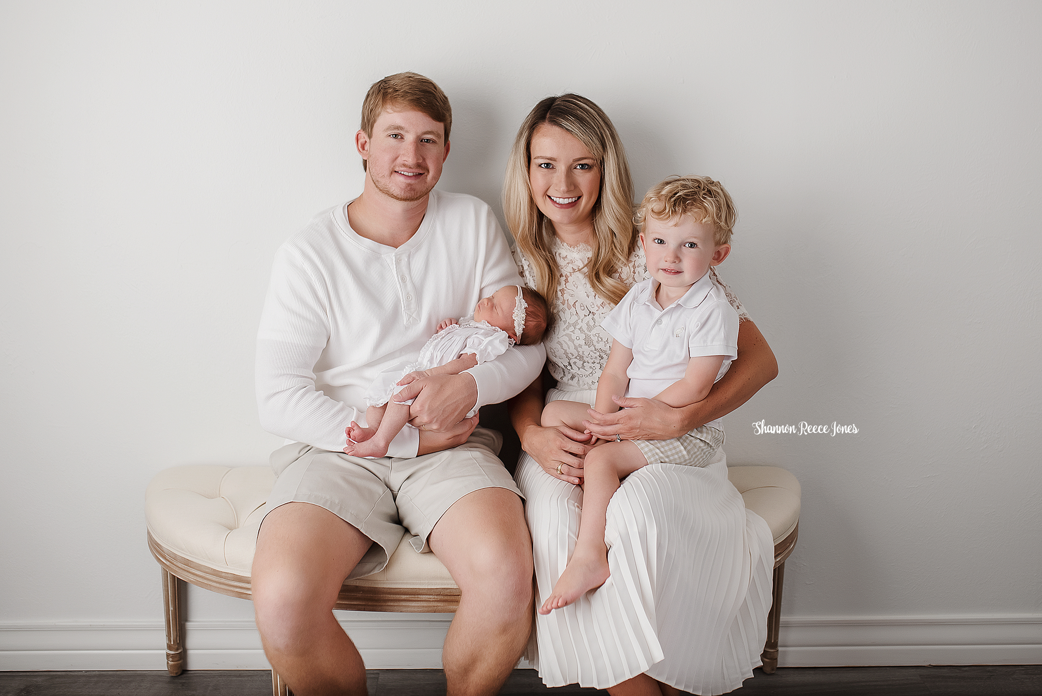 newborn and family pictures, family seated on bench indoors