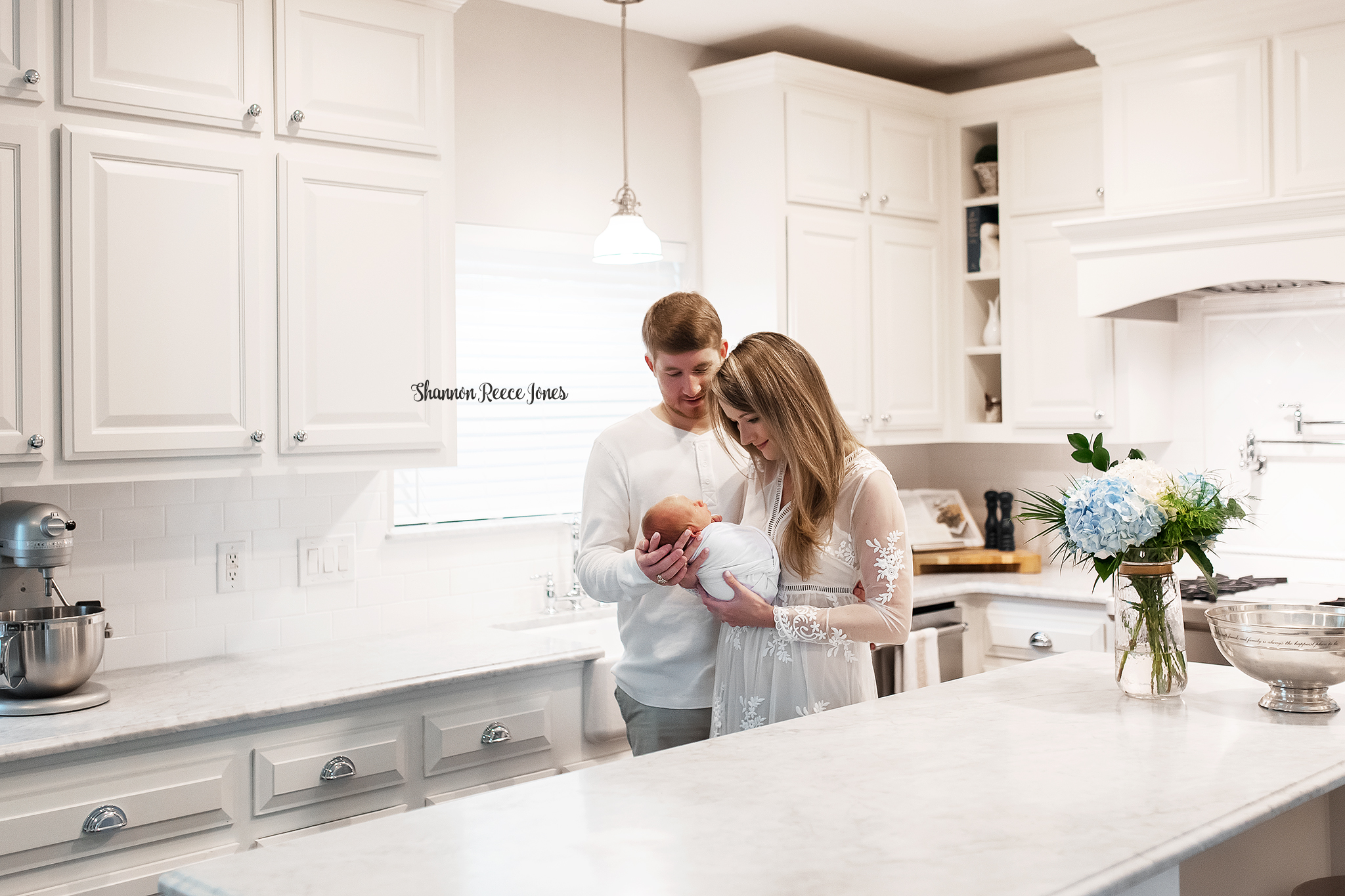 lifestyle photography, parents holding newborn baby in kitchen