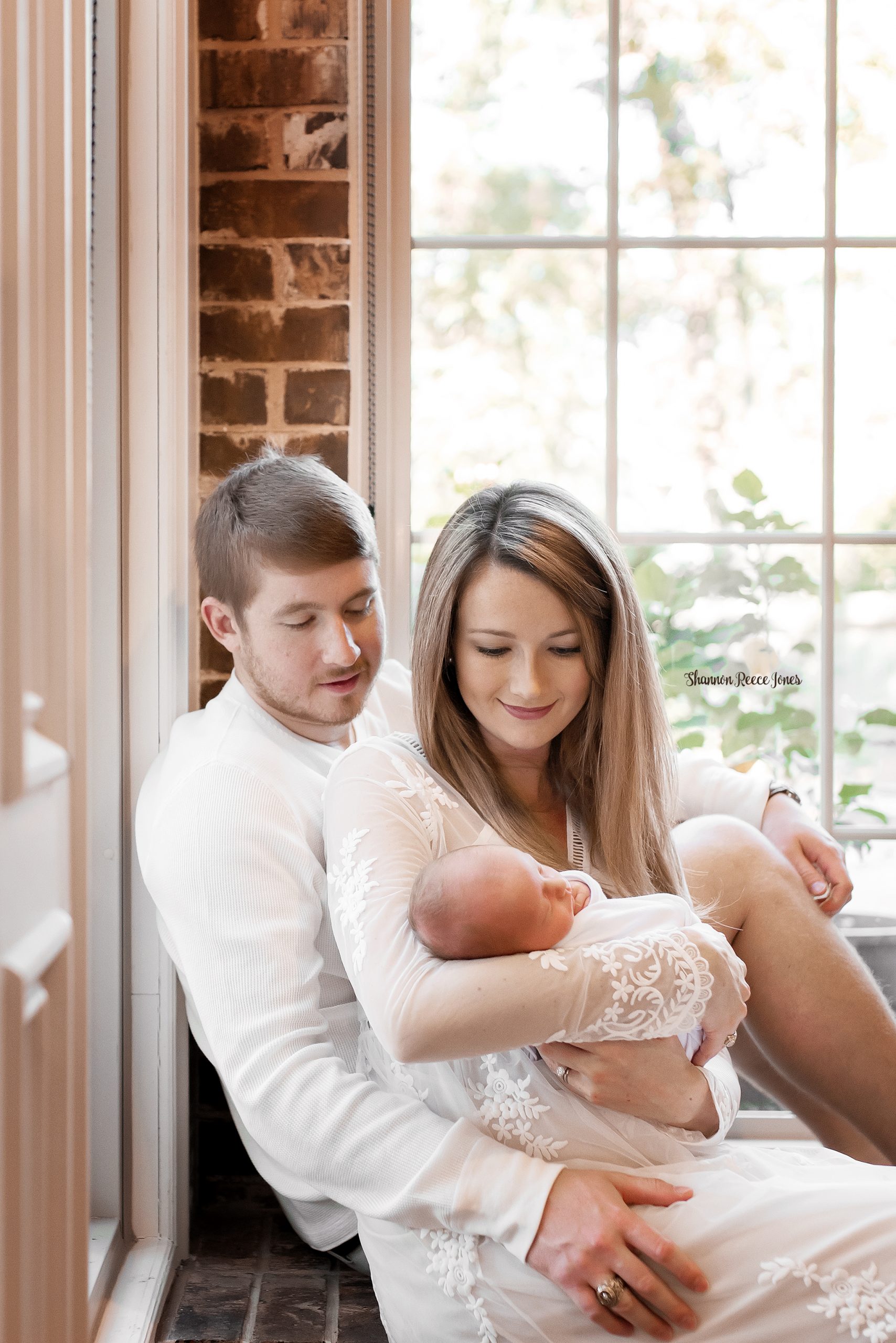 lifestyle newborn photographer texas, parents holding baby by window