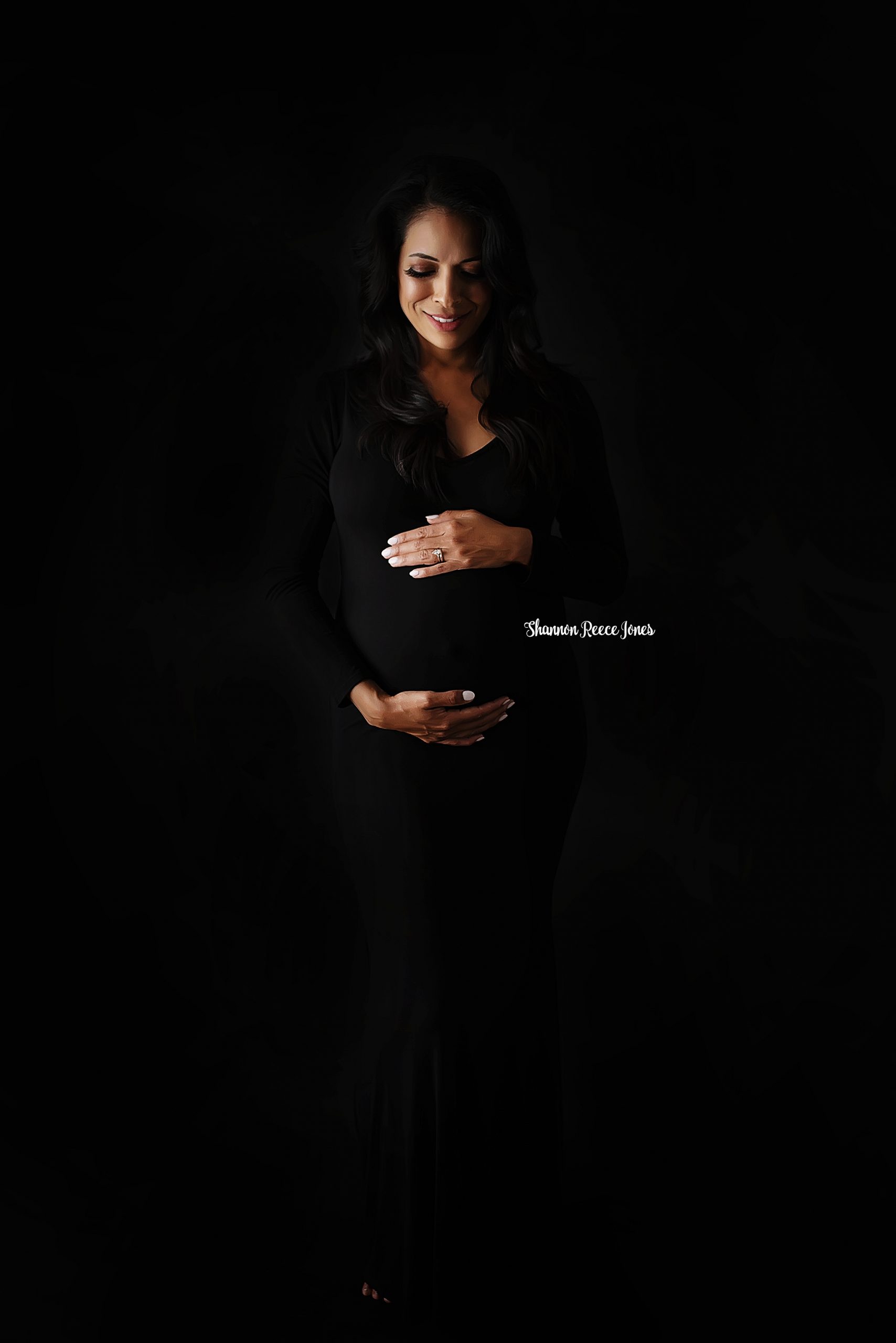 maternity pictures houston texas, pregnant mother in black dress against black backdrop