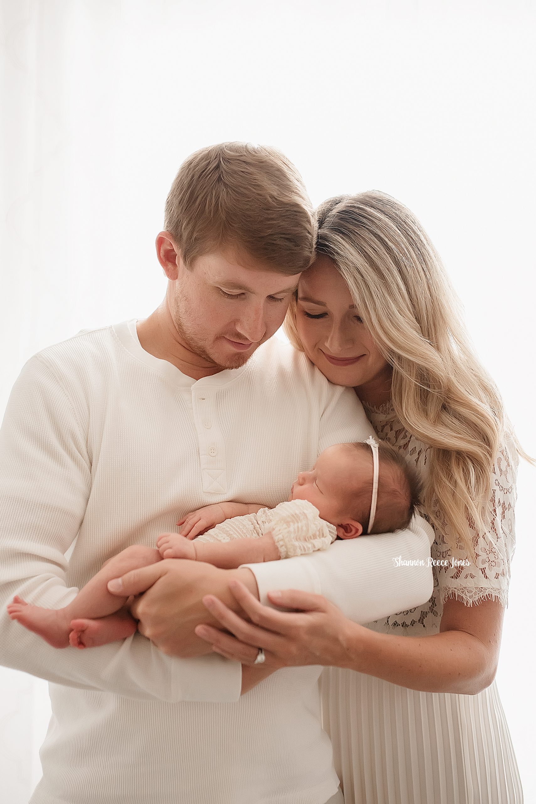 studio newborn photographer texas, parents holding baby daughter in white