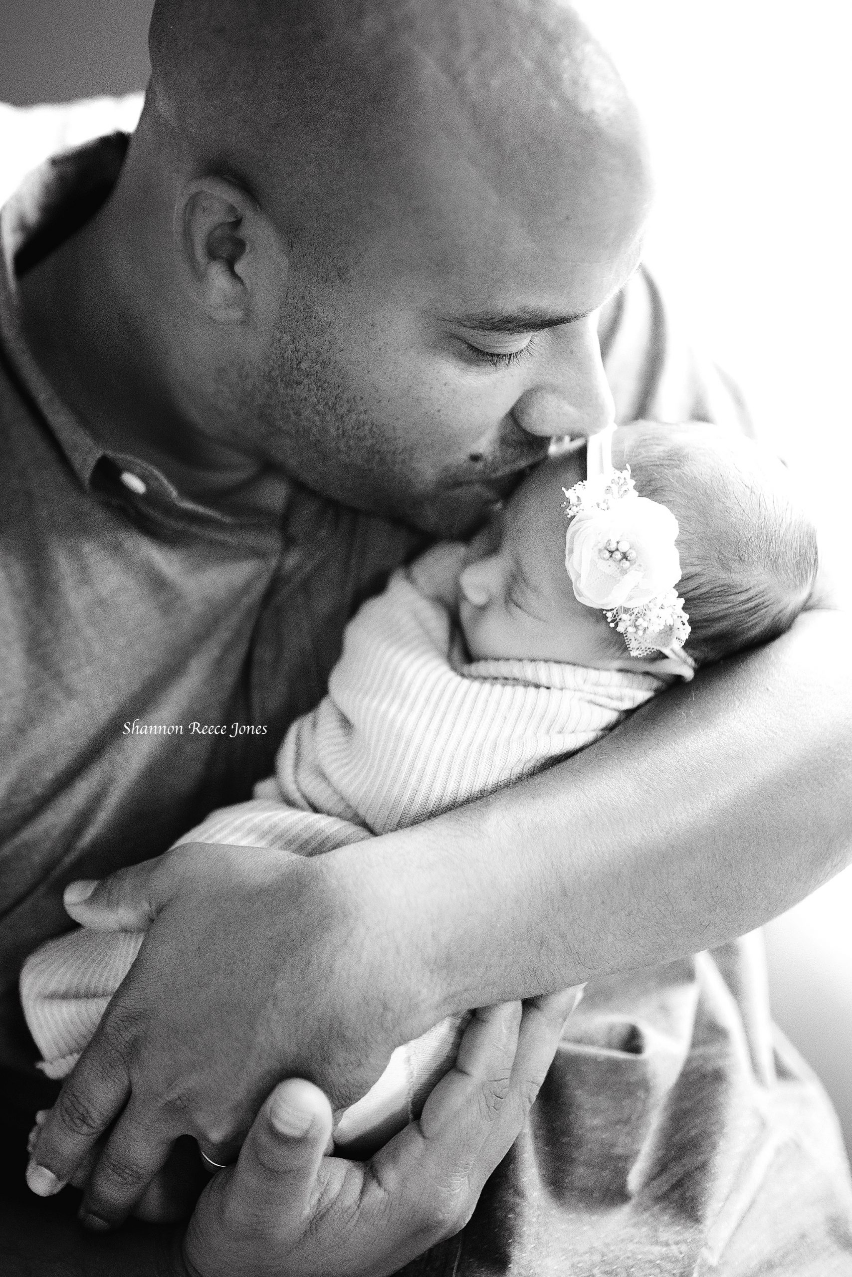 best newborn photographers houston tx, black and white image of dad kissing baby girl