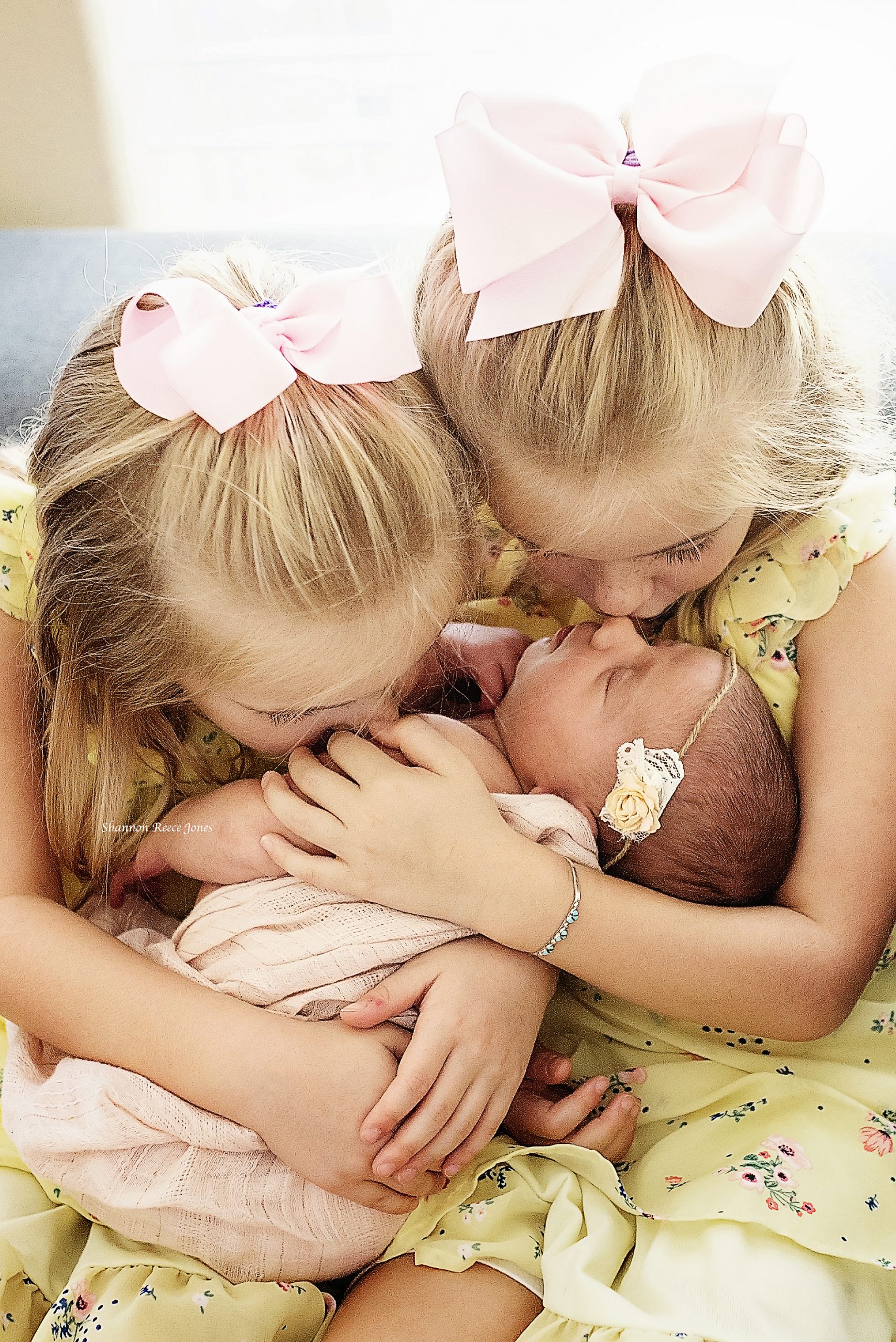 sisters holding baby girl