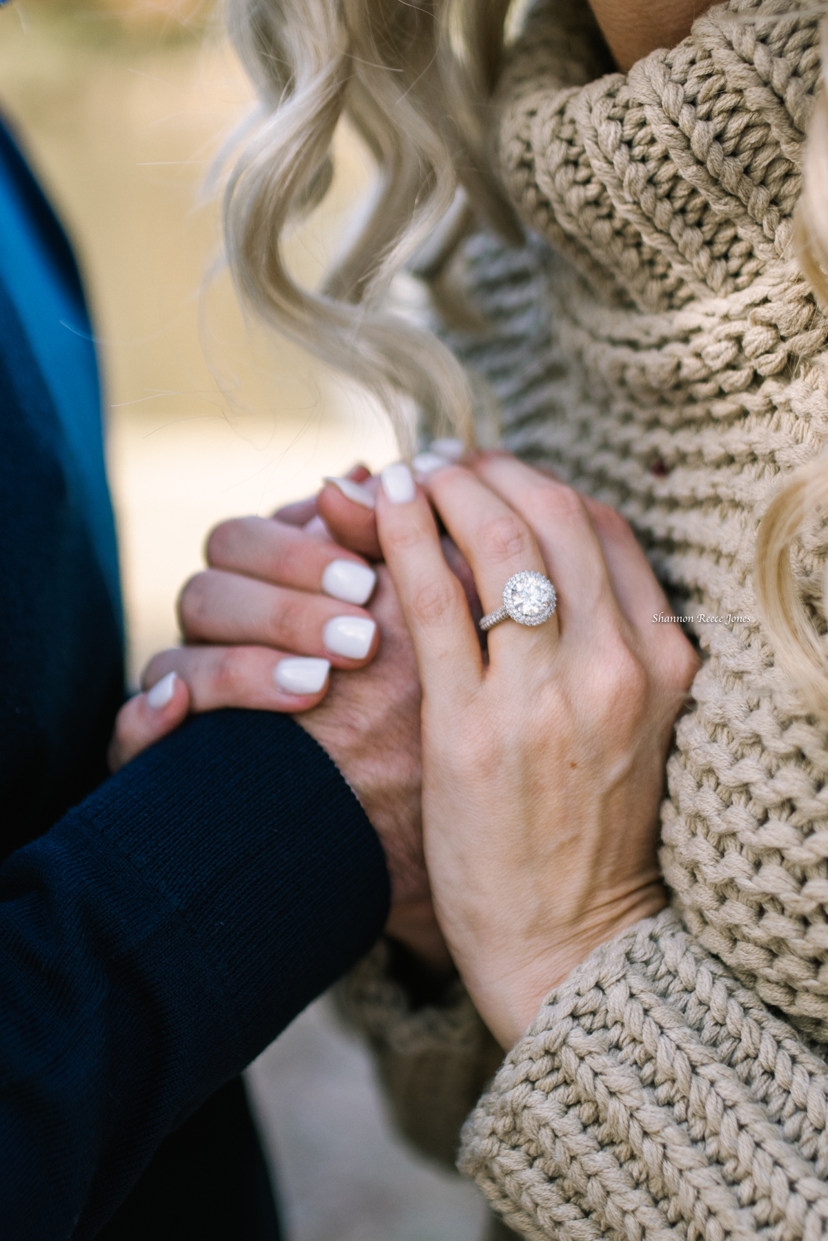 Closeup of couple's hands with engagement ring