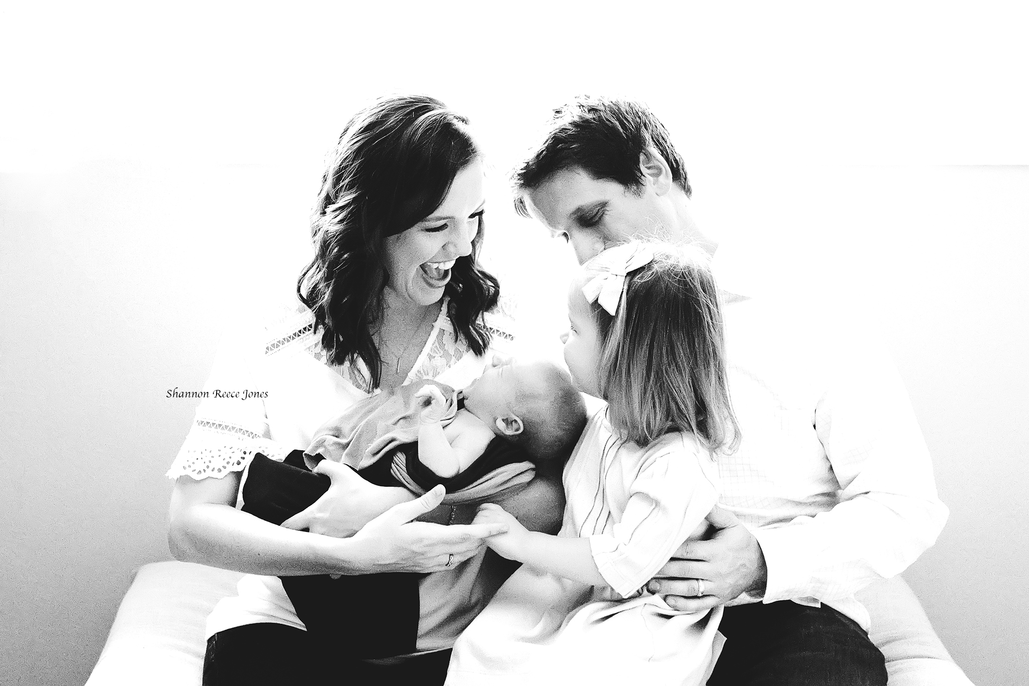 black and white family photo with toddler and newborn