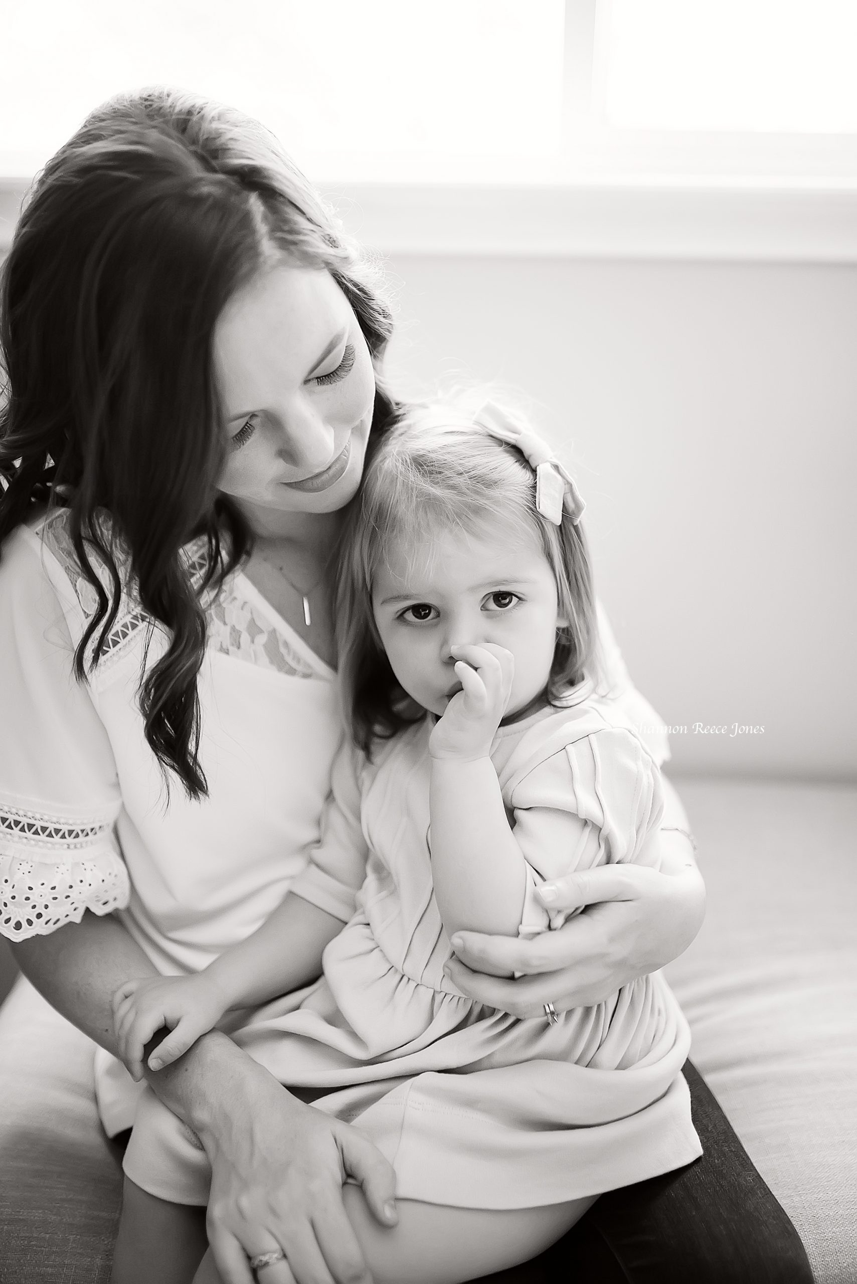 black and white mom holding daughter at home