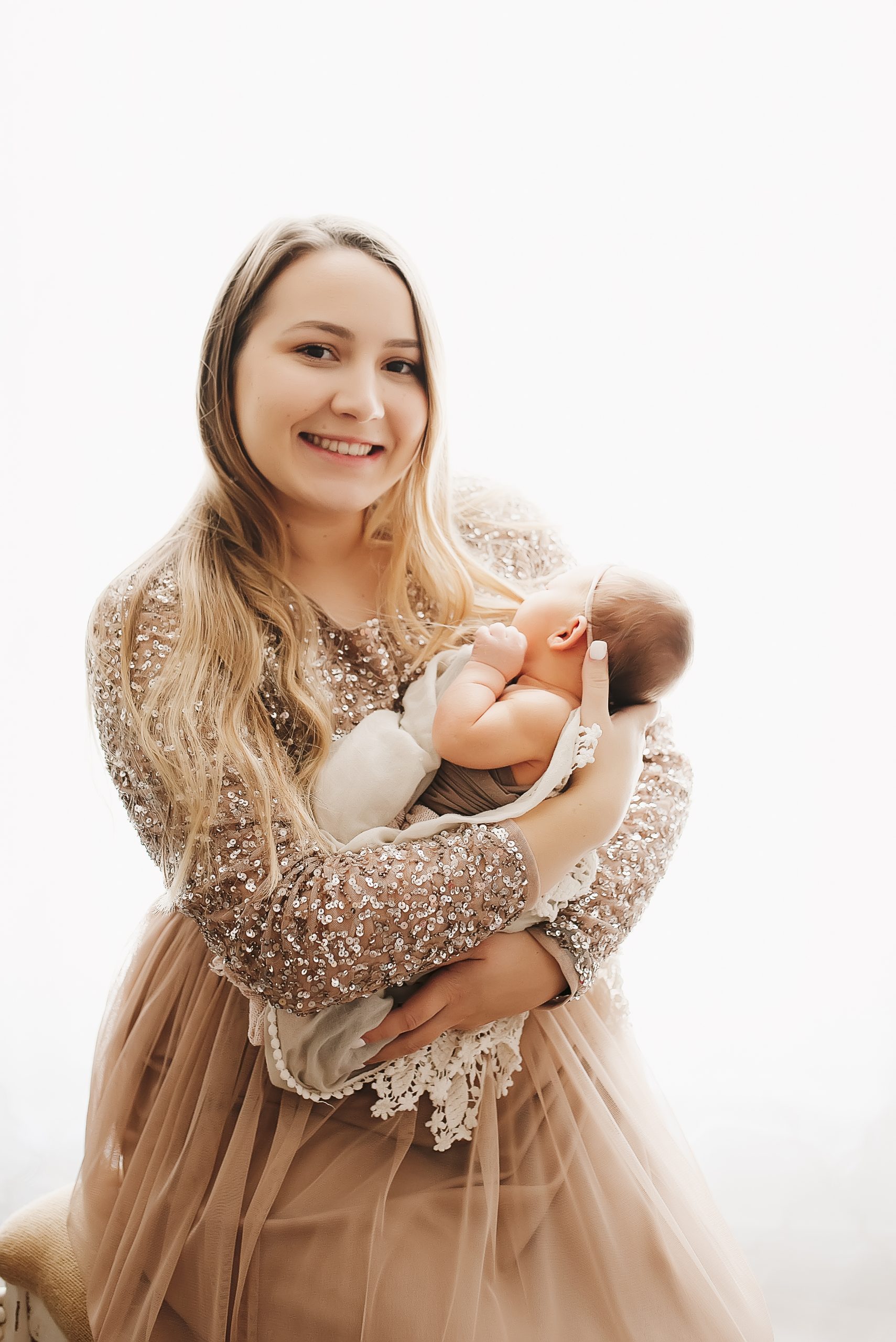 newborn photography, mother in sparkly dress holding infant