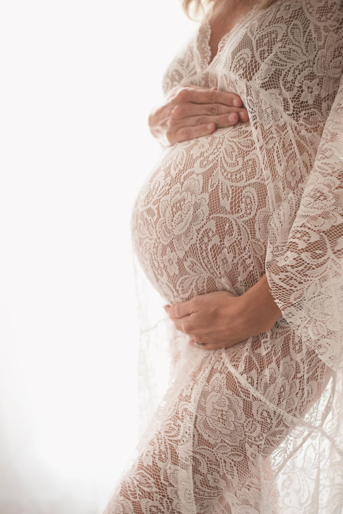 closeup of baby bump white lace maternity gown