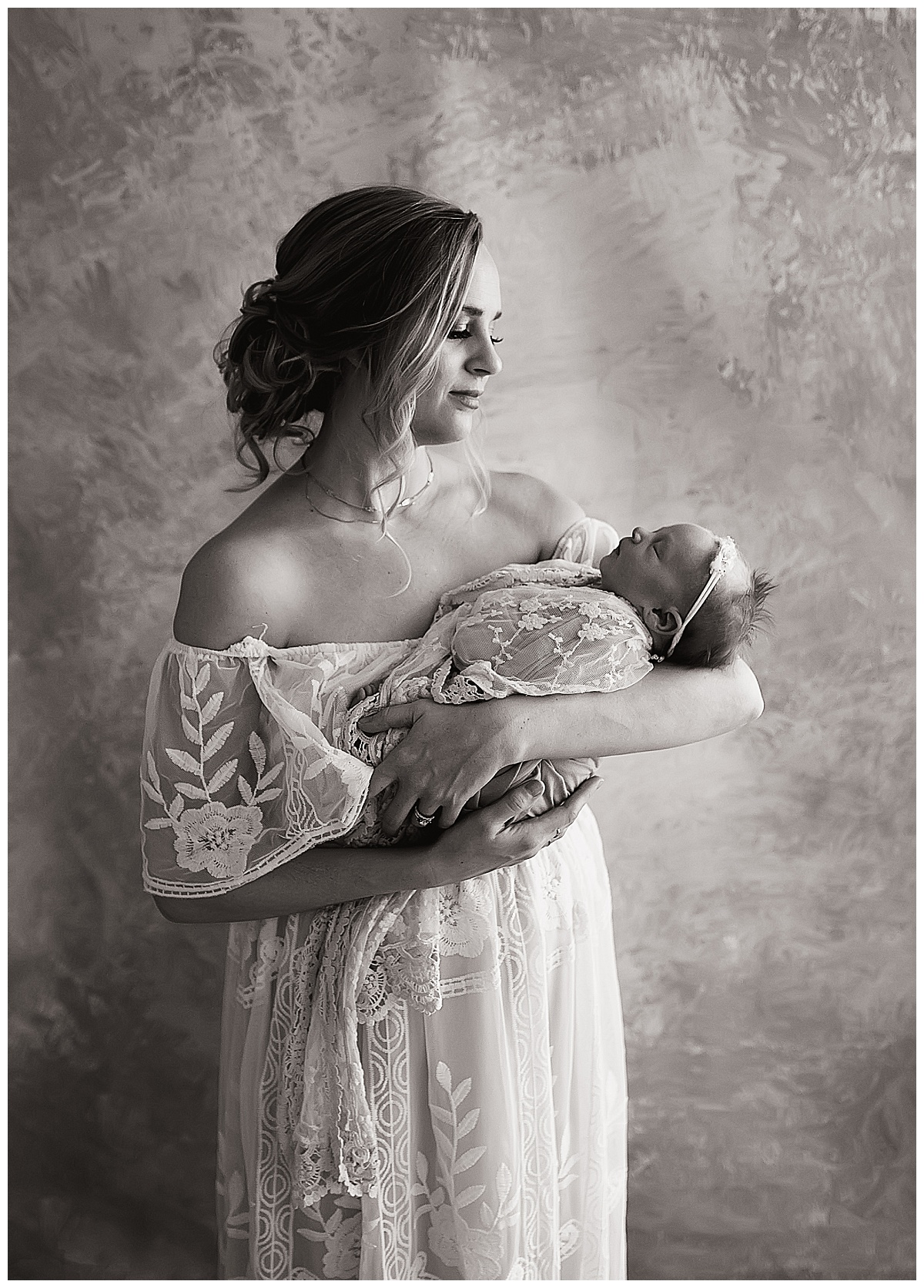 black and white photo of mother holding newborn baby girl