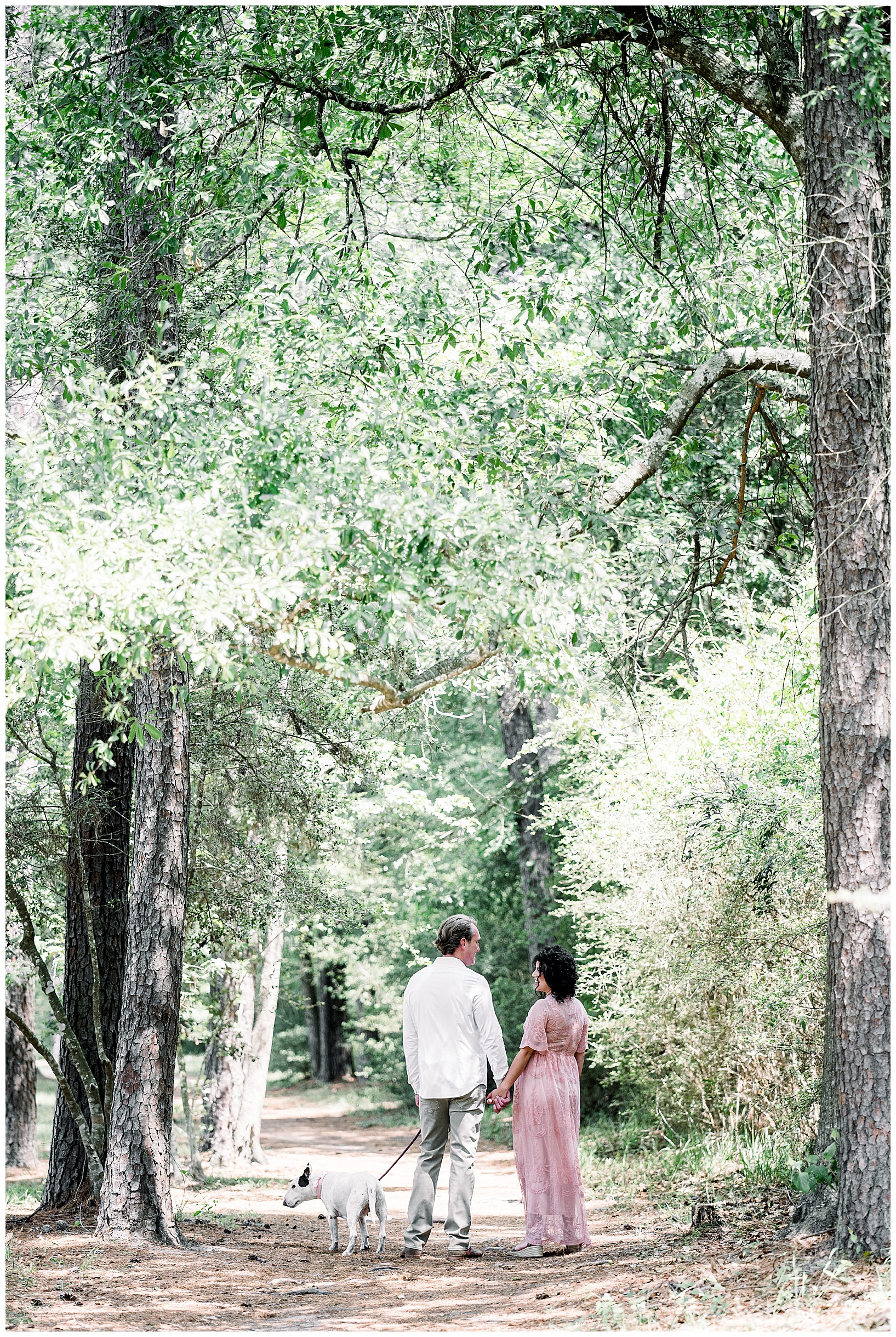 Couple walking under trees in Conroe Texas during maternity photography session