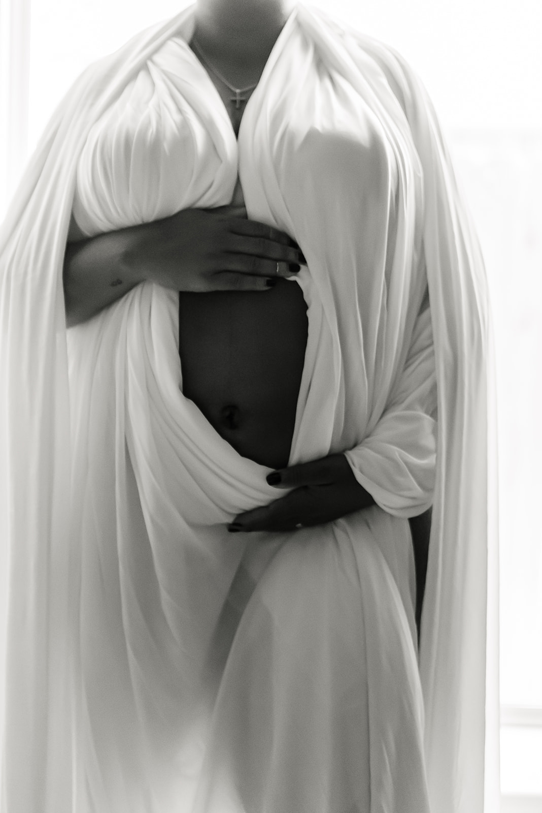 Woman wearing white wrap for maternity photos