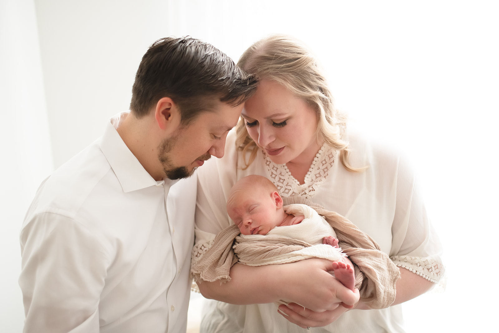 Parents holding newborn during luxury at-home lifestyle photo session