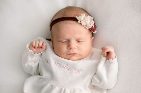 Baby girl in white monogrammed dress and floral headband