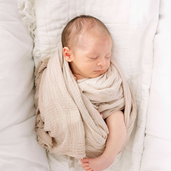 newborn baby boy lying swaddled in bassinet in his home in Houston TX