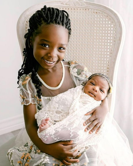 Big sister holding newborn baby in Houston Texas SRJ Photography studio