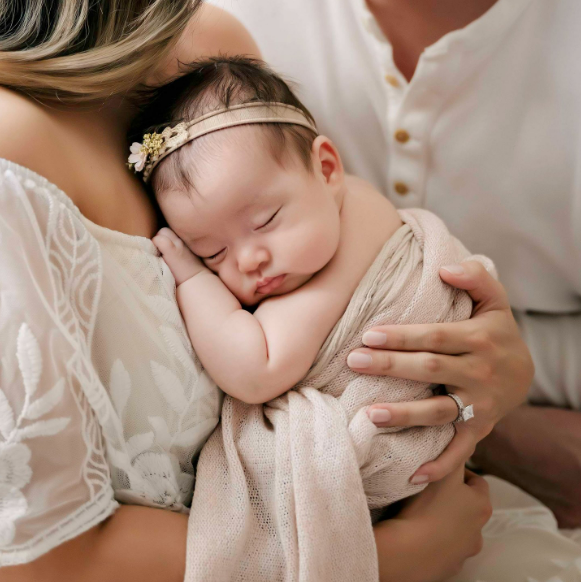 Newborn baby curled up against mom's chest