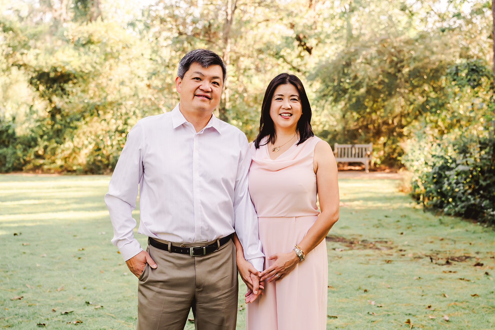 Asian American couple holding hands as they pose for a portrait during a Houston family session