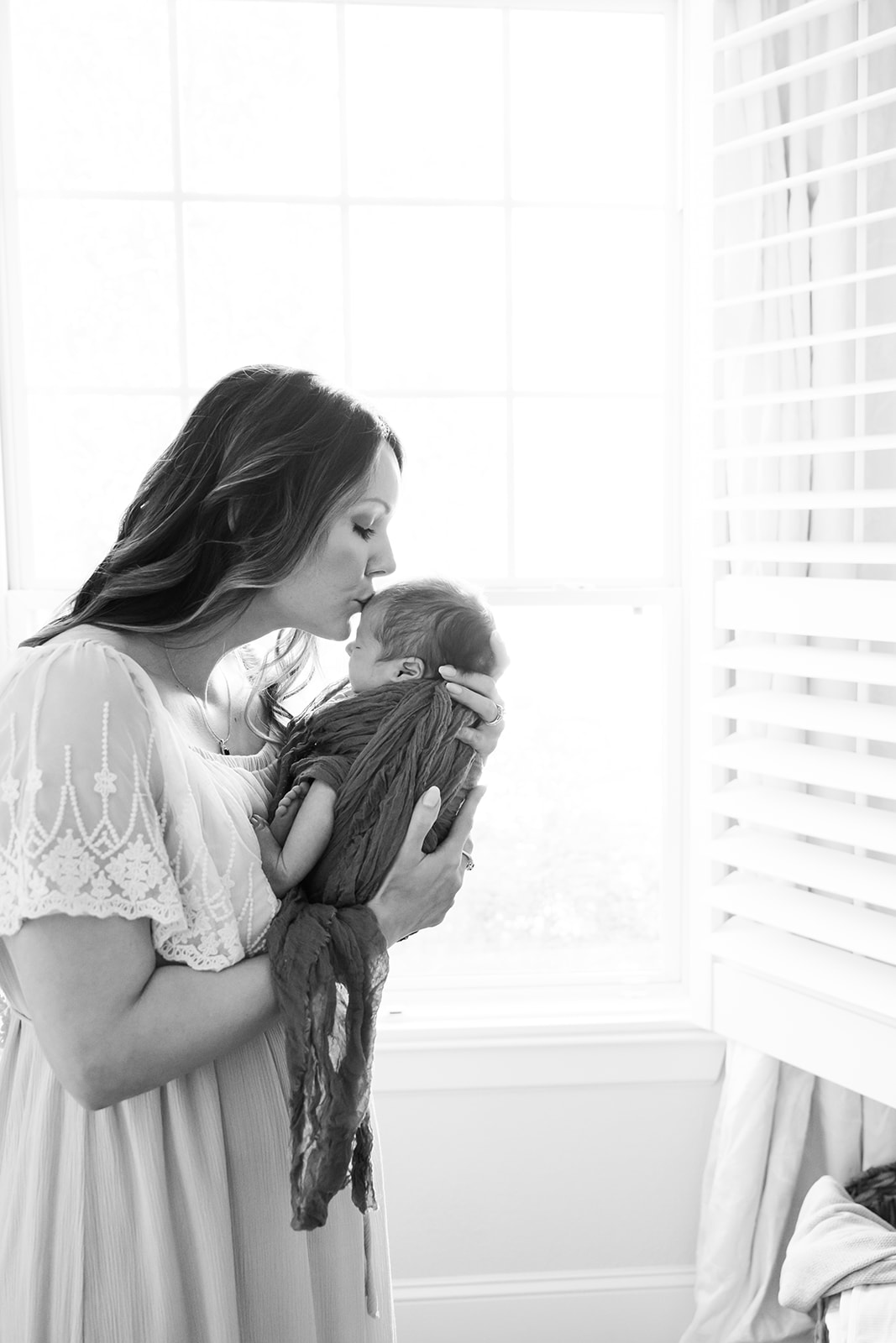 Black and white newborn photography picture of mom holding baby with Houston newborn photographer