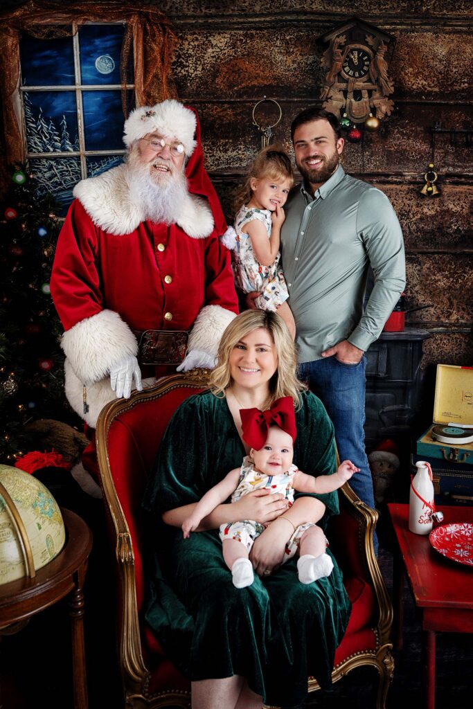 Family Christmas card portrait with Santa featuring mom, dad, and children during a holiday photo session in Houston