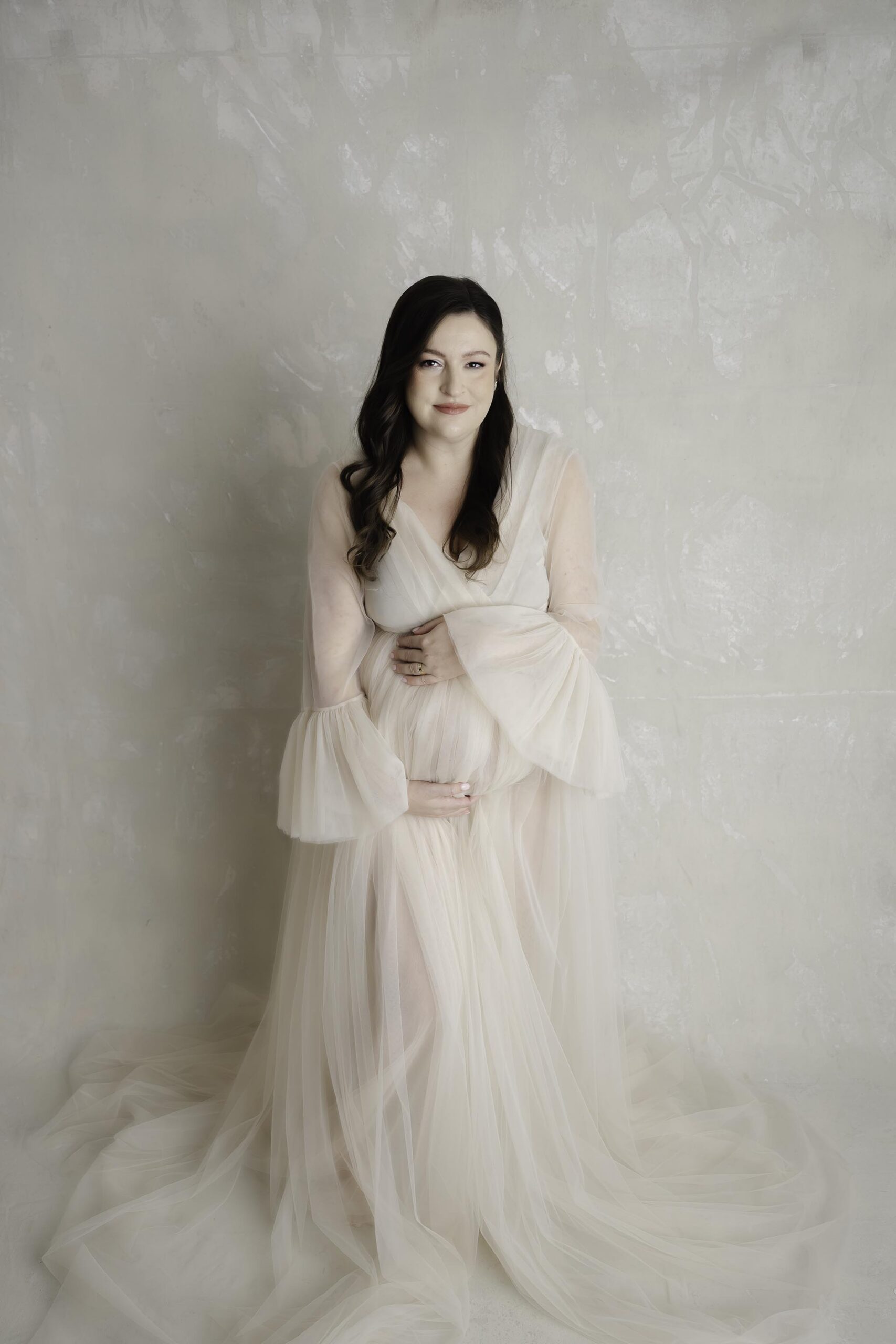 Houston maternity photographer with expecting mother in studio gown